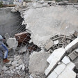 Man stands next to demolished building