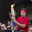 Palestinian Christian worshiper carrying a flame among the crowd. 