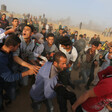 Crowd of protesters carry injured man