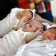 Photo shows three swaddled newborns lying on their backs