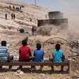 Palestinian children watching an Israeli bulldozer 