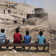 Palestinian children watching an Israeli bulldozer