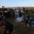 Crowd of men running amid clouds of tear gas