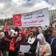 Protesters hold up banners on the street. 