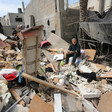 Man sits on pile of rubble and household items