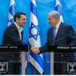 Leaders of Greece and Israel shake hands in front of Israeli flags