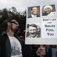 A man holds sign with pictures of Ilhan Omar and Hitler