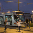 Youths throw stones at a tram