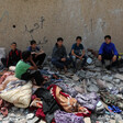 Six boys surrounded by rubble and damaged belongings