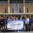 People holding banner pose for large-group photo