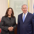 Two politicians stand in front of Israeli and American flags