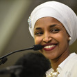 A woman smiles in front of a microphone.