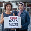 Two women hold sign