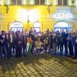 Large group of people stands in front of building