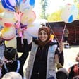  A charity worker hands out ballons to children