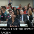 A woman stands at a microphone