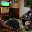 Five men watch football match on television