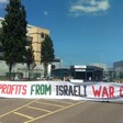 Seven activists hold up a huge banner against Israeli war crimes