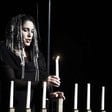 Woman lighting menorah candles 