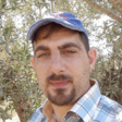 Man wears a cap standing in front of olive branches