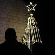 Silhouette of a man near a lit Christmas tree 