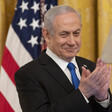 Benjamin Netanyahu smiles and claps his hands