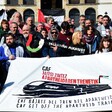 A large group of people holds a banner