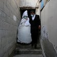 Woman in wedding dress and man in suit stand on steps