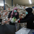 Women pour dry beans into bags