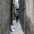 Walls tower over a child in a narrow passage