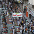 Aerial view of men praying on a shop-lined street