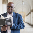 A standing man reads a book