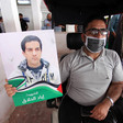 Man in wheelchair holds poster of Iyad Hallaq