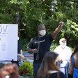 Masked man with raised fist along with masked crowd