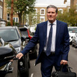 A man in a suit entering a car