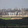 Construction cranes tower over apartment buildings