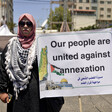 Woman in sunglasses holds sign