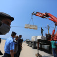 Officers stand by as crane lifts boulders