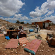 Damaged furniture and rubble on open land 
