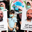 Children wearing face masks hold posters