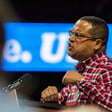 Man makes fists while speaking at podium