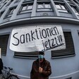 A man in face mask holds up a sign in German