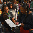 Woman signs book with onlookers