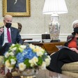 Man and woman in face masks sit on chairs