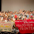 Activists gather on a stage and hold banners