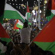 Crowd waves Palestinian flags in town square