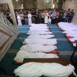 People pray at the mosque over 17 bodies wrapped in shrouds