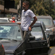 Man steps out the door of his car amid queue 