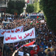 Large crowd of demonstrators holding two large banners, flags 