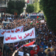 Large crowd of demonstrators holding two large banners, flags